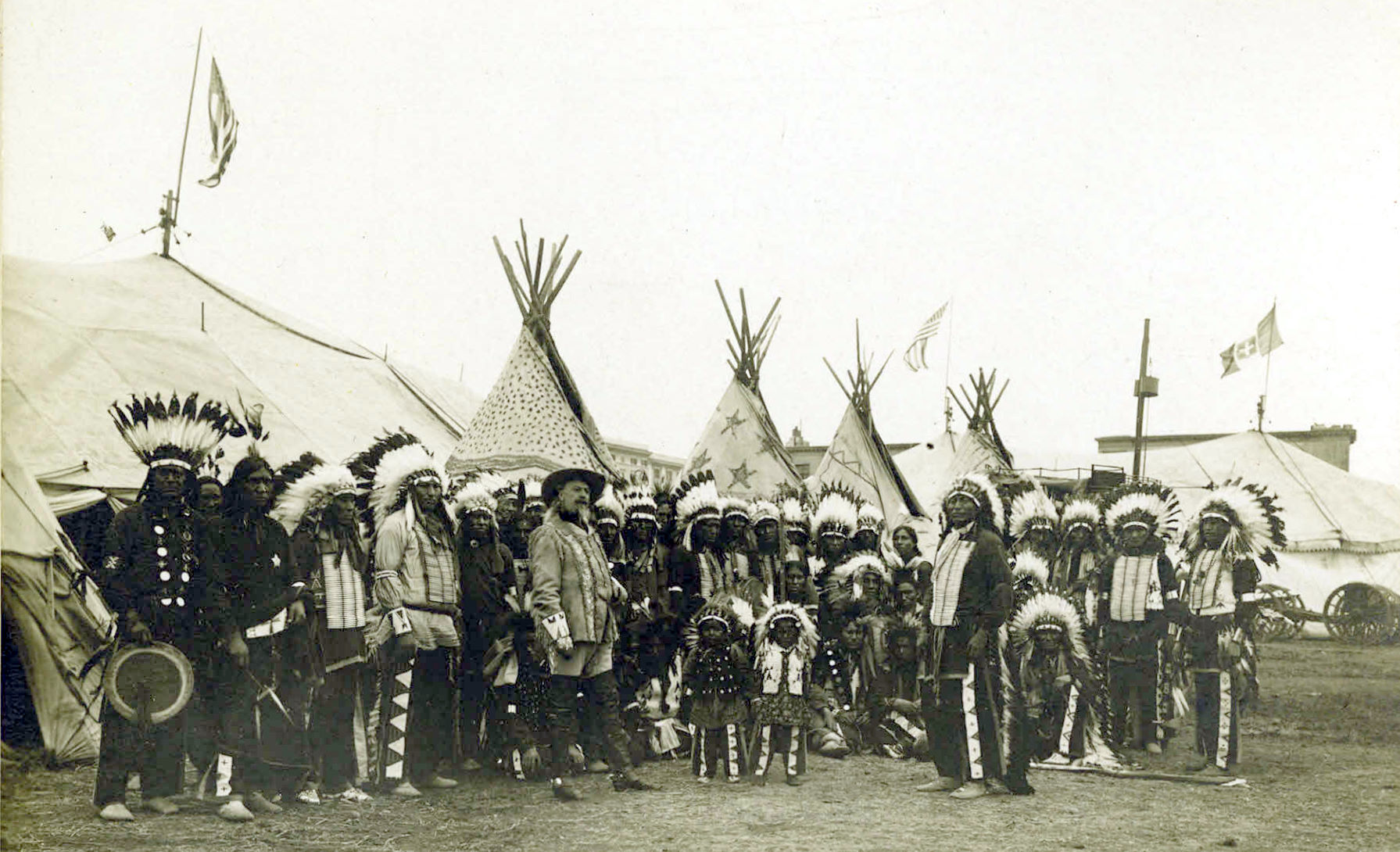 Arena scene from Buffalo Bill's Wild West Show, with mounted performers and a large outdoor audience in the grandstands.