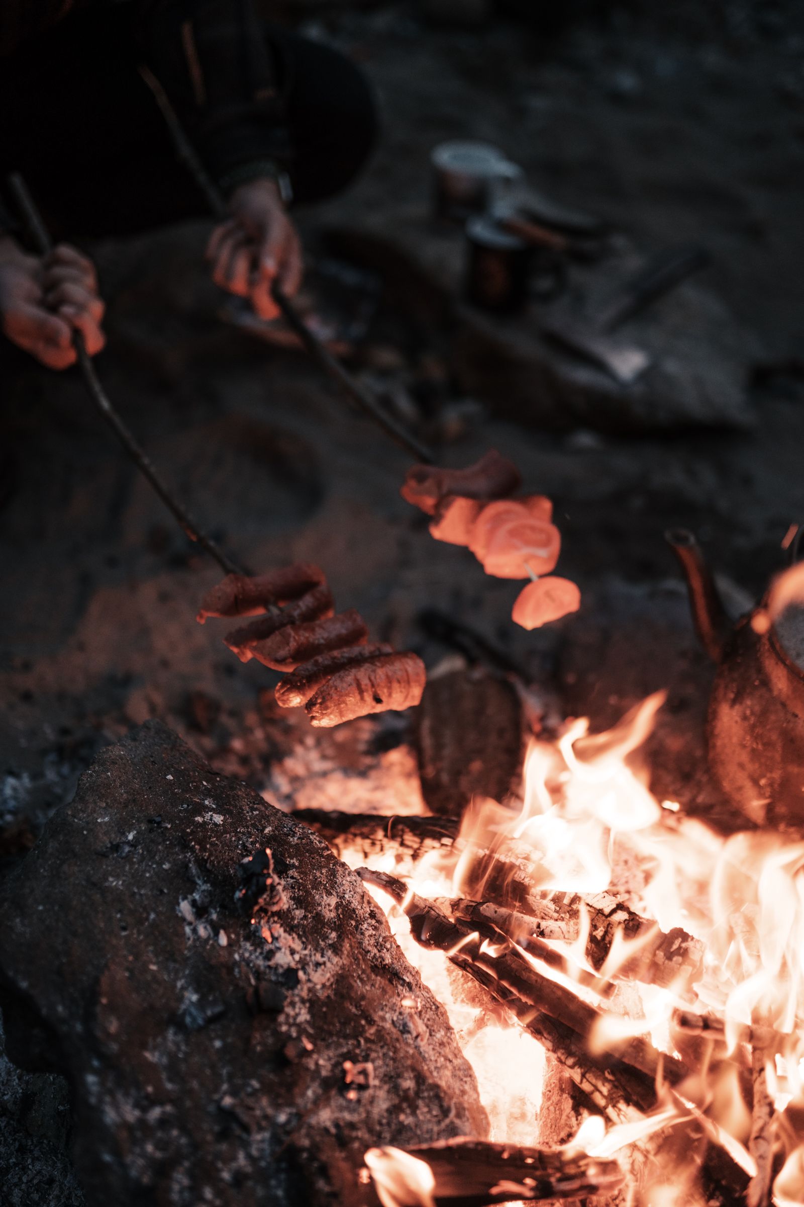 Campfire cooking scene in an outdoor backcountry setting, the modern context where a possibles bag still serves its original purpose.