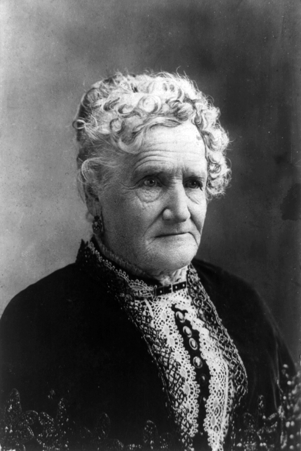 Portrait photograph of Esther Hobart Morris, suffragist and first woman to hold judicial office in the United States, in formal dress of the 1870s era.