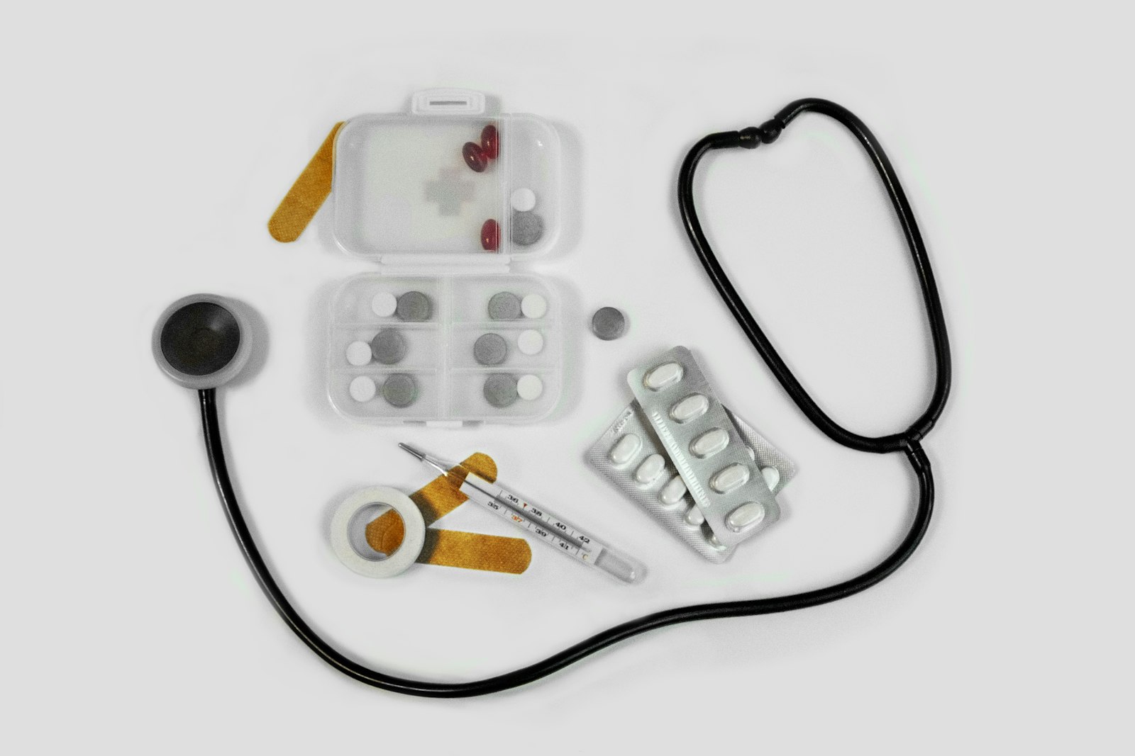 Open canvas first aid kit on the tailgate of a pickup truck, with bandages, a tourniquet, irrigation syringe, and trauma shears organized in compartments.