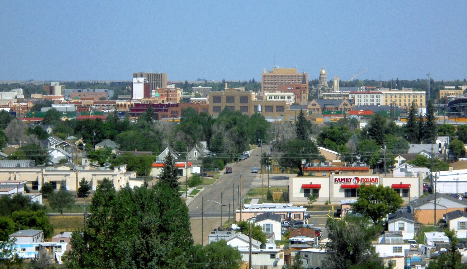 Wyoming State Capitol building in Cheyenne, Wyoming, with its gold-leaf dome and limestone facade against a clear blue plains sky.