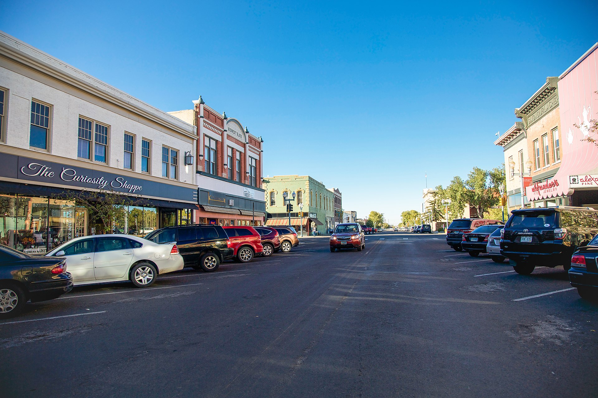 Historic downtown Laramie, Wyoming, with restored brick storefronts along Ivinson Avenue and the Snowy Range visible in the distance.