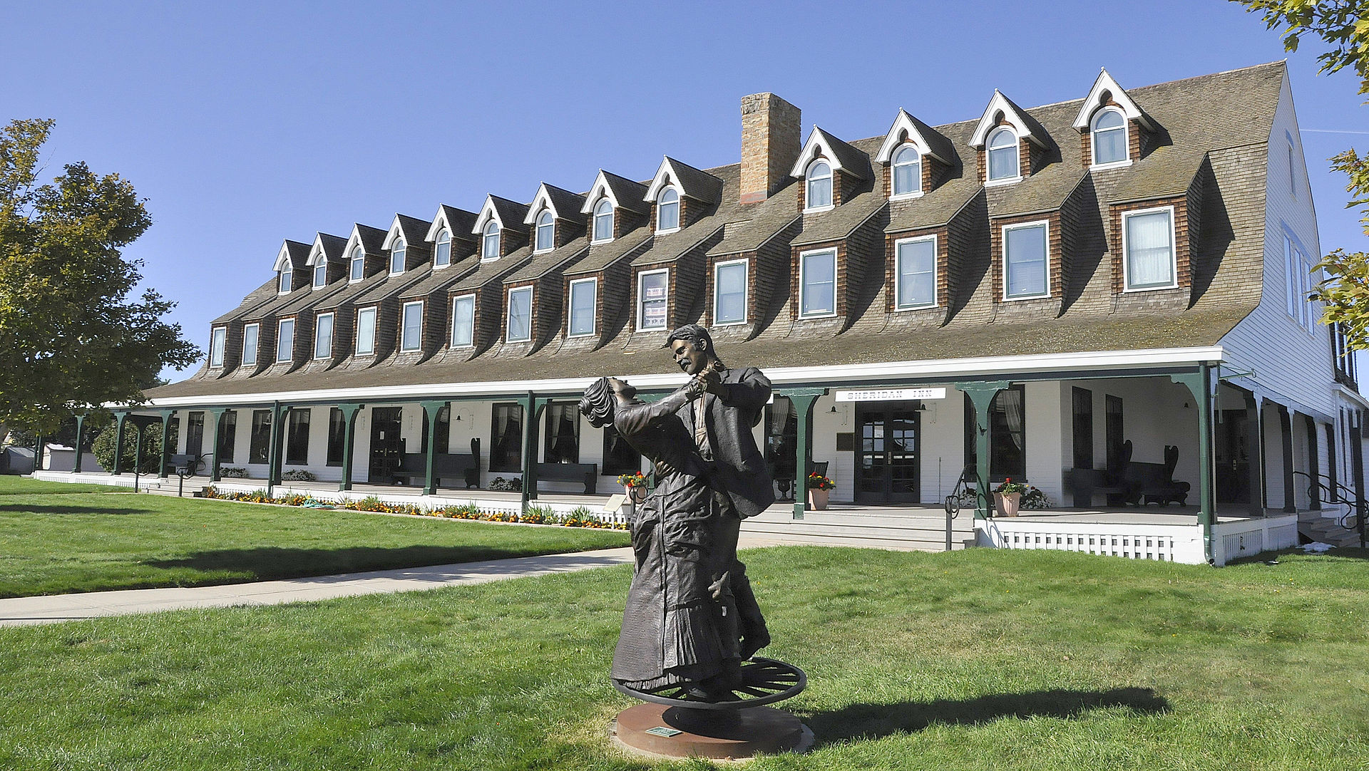 The historic Sheridan Inn, a large Victorian-era wooden hotel with wrap-around porches and a distinctive gambrel roof, in downtown Sheridan, Wyoming.